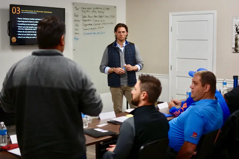 Ryan Groth leading a contractor sales training session with STG methodology on whiteboard